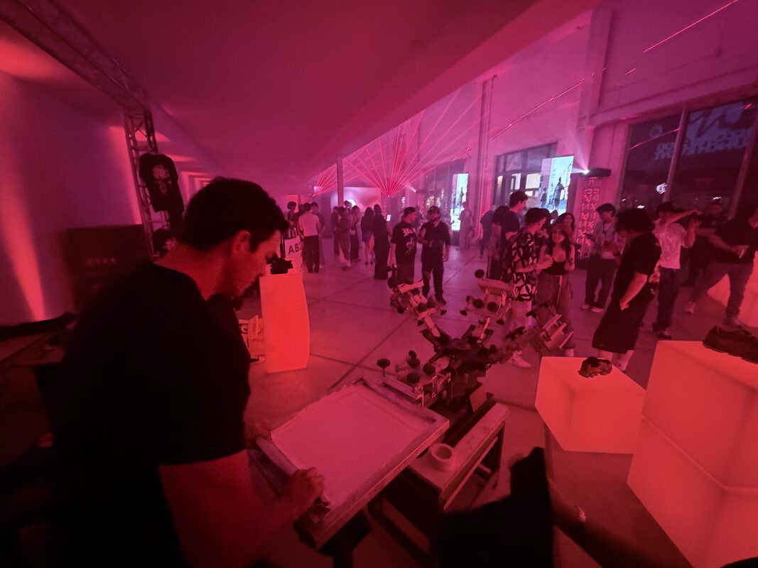Live customization station glowing under red lights at a crowded warehouse party